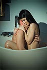 Lovely naked couple hugging each other when taking a bath together.