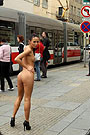 A girl in high heels getting naked on a busy bus station.